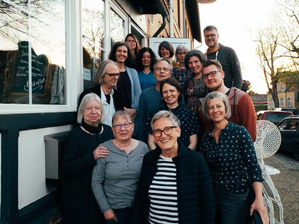 Gruppenfoto der Mitglieder von Kreuzpunkt Michendorf e. V. vor einer Tür auf dem Gehweg.