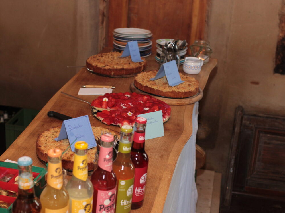 Büffet mit Kuchen und Limonaden, Geschirr auf einem Holztisch.