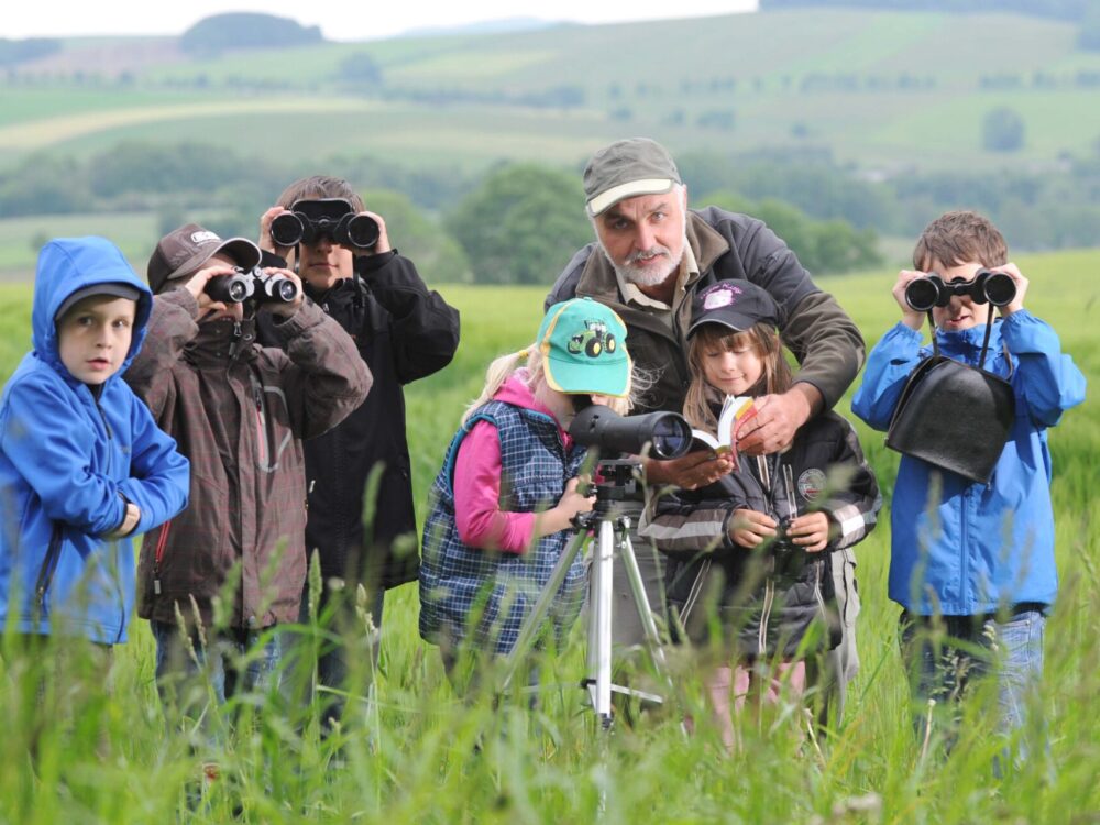 Leiter der Grünen Schule Christoph Weidensdörfer mit einer Kindergruppe auf Zethauer Flur zur Vogelbeobachtung unterwegs.